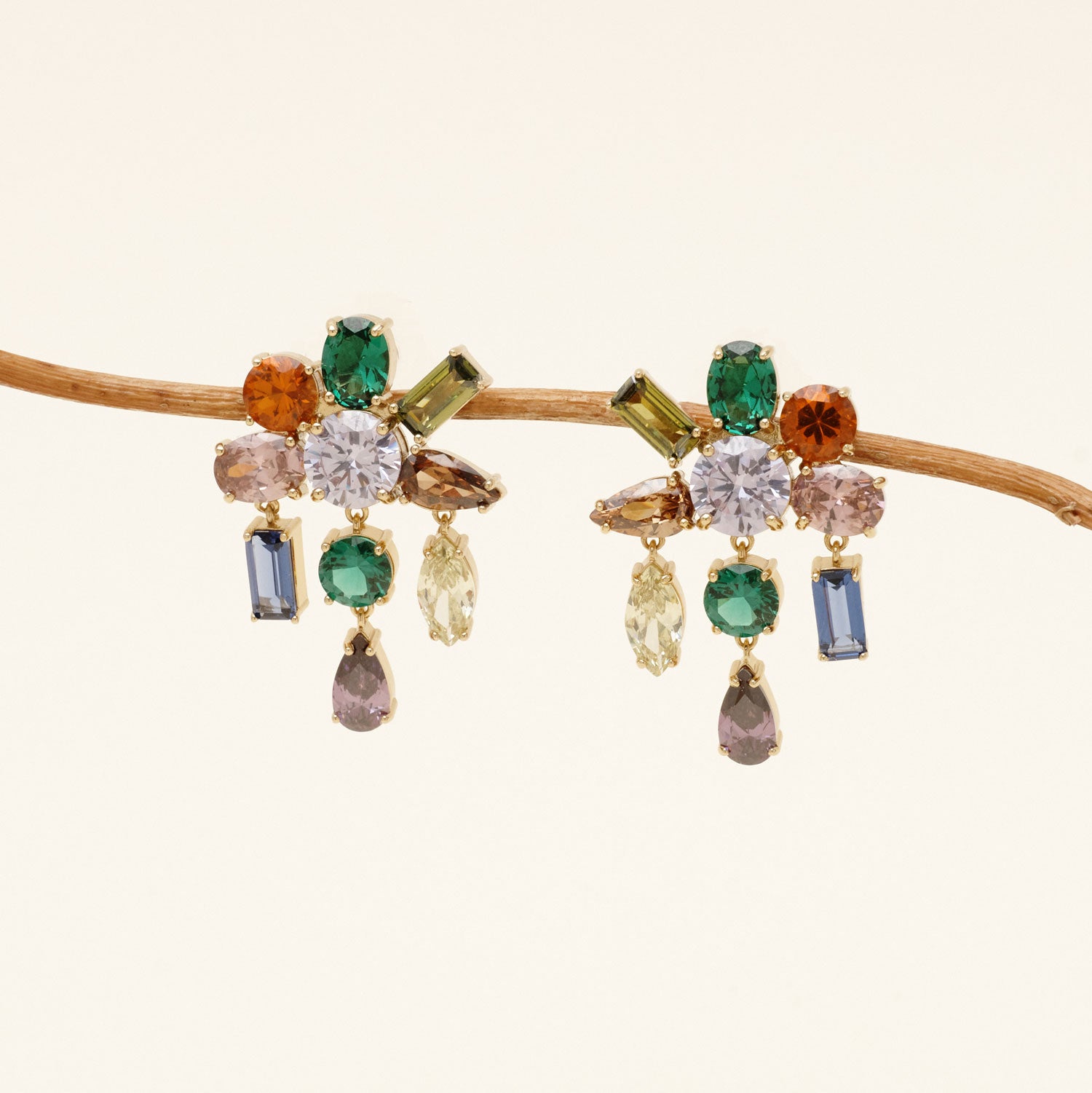 a pair of crystal earrings featuring nine crystals of different colors on each earring dangling from a thin branch