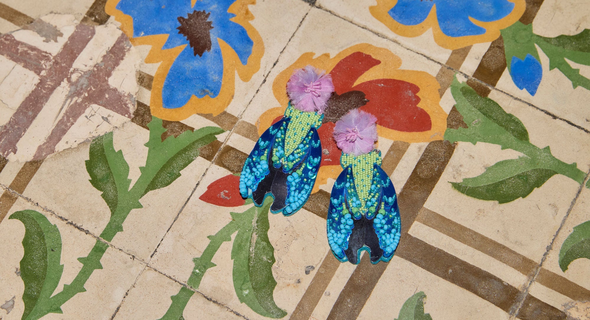 Model wearing colorful and bold earrings with sunglasses