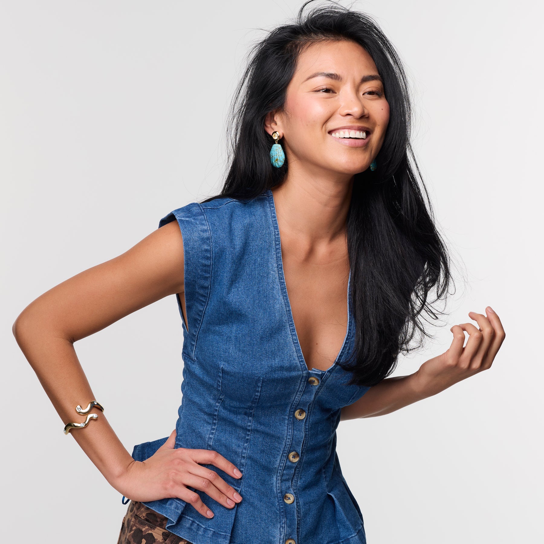 Woman wearing a blue denim dress against a plain background