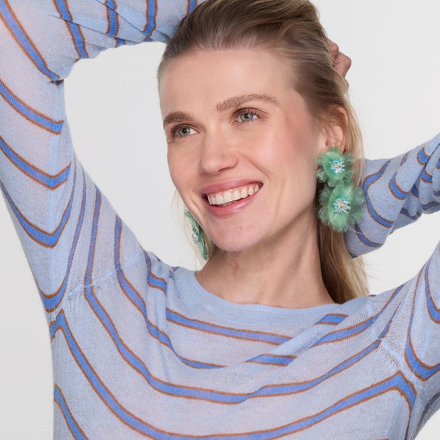 Green and blue embroidered earrings on model