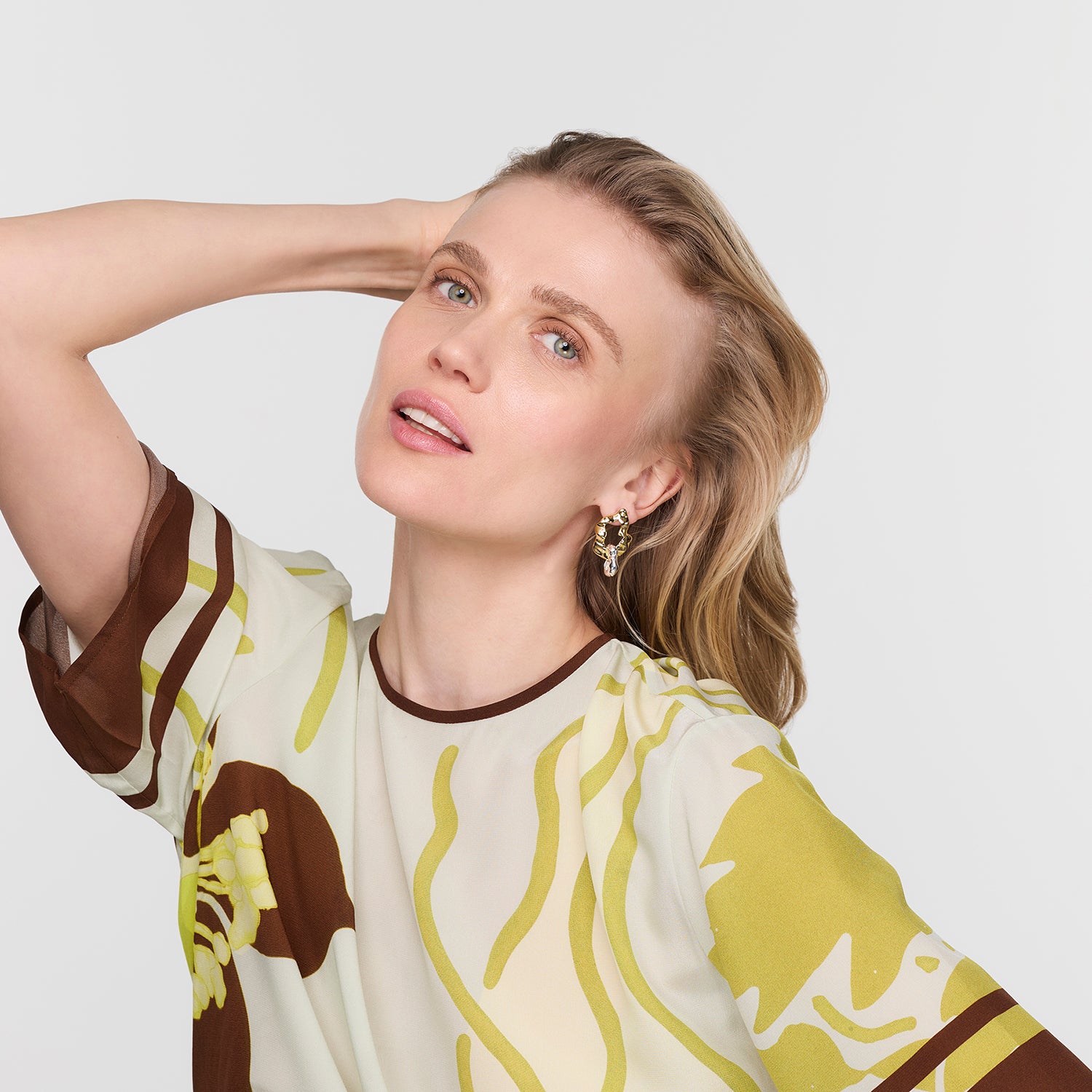 Woman wearing a patterned shirt with a plain background