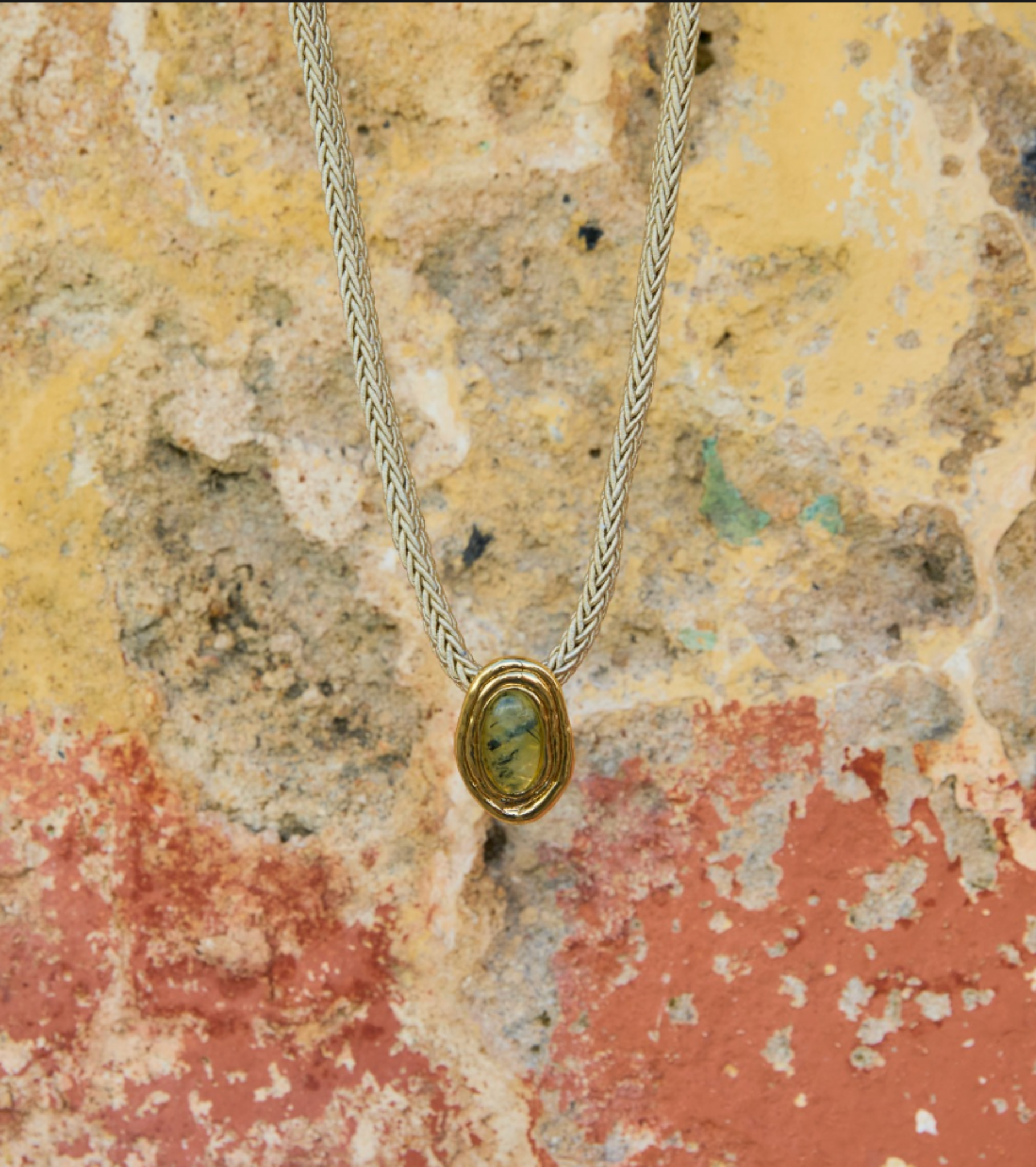 Gold necklace against stone wall background