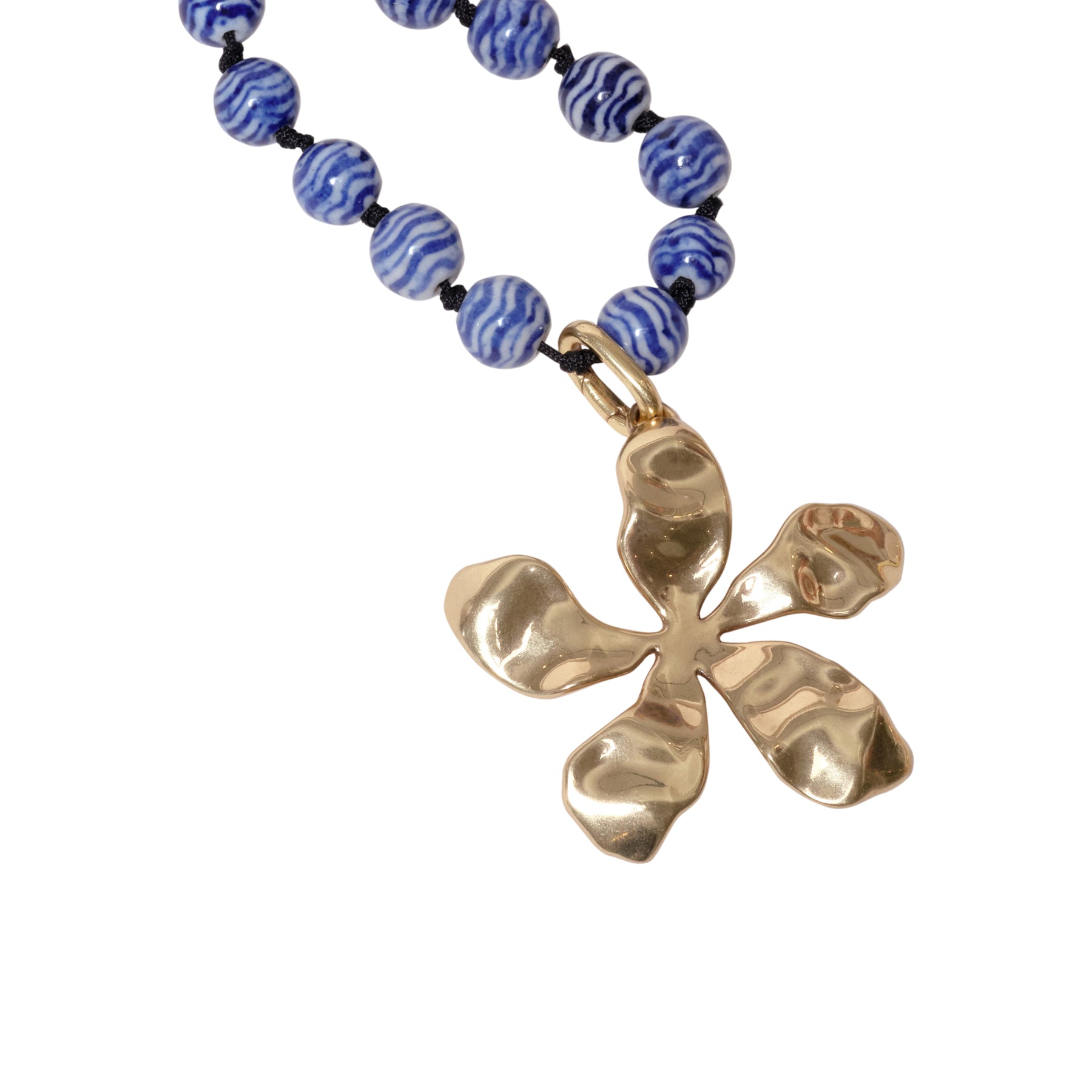 Blue and White Marbled Glass Bead Strand with Gold Organic Flower Pendant Charm on Flat White Background