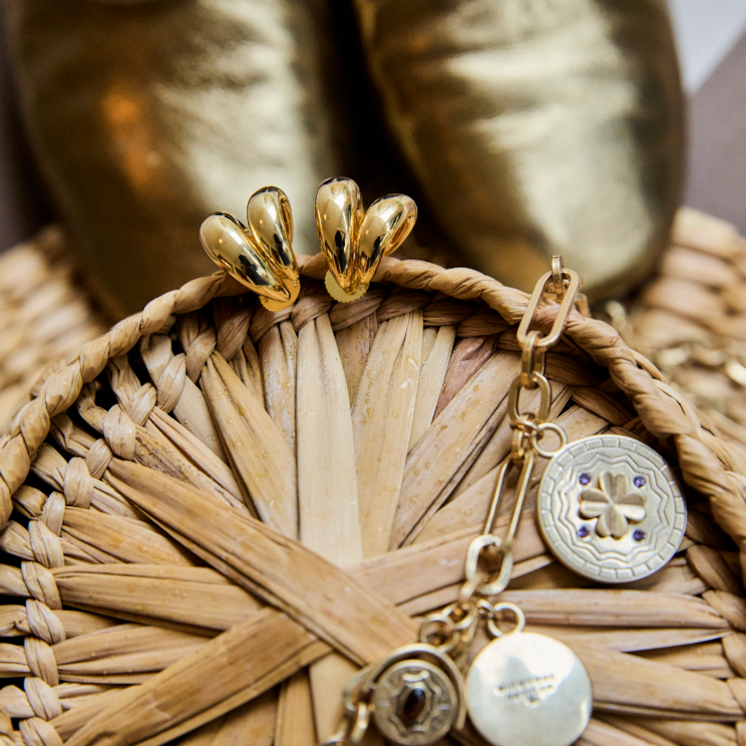 Gold hoop earrings and gold chain necklace on basket