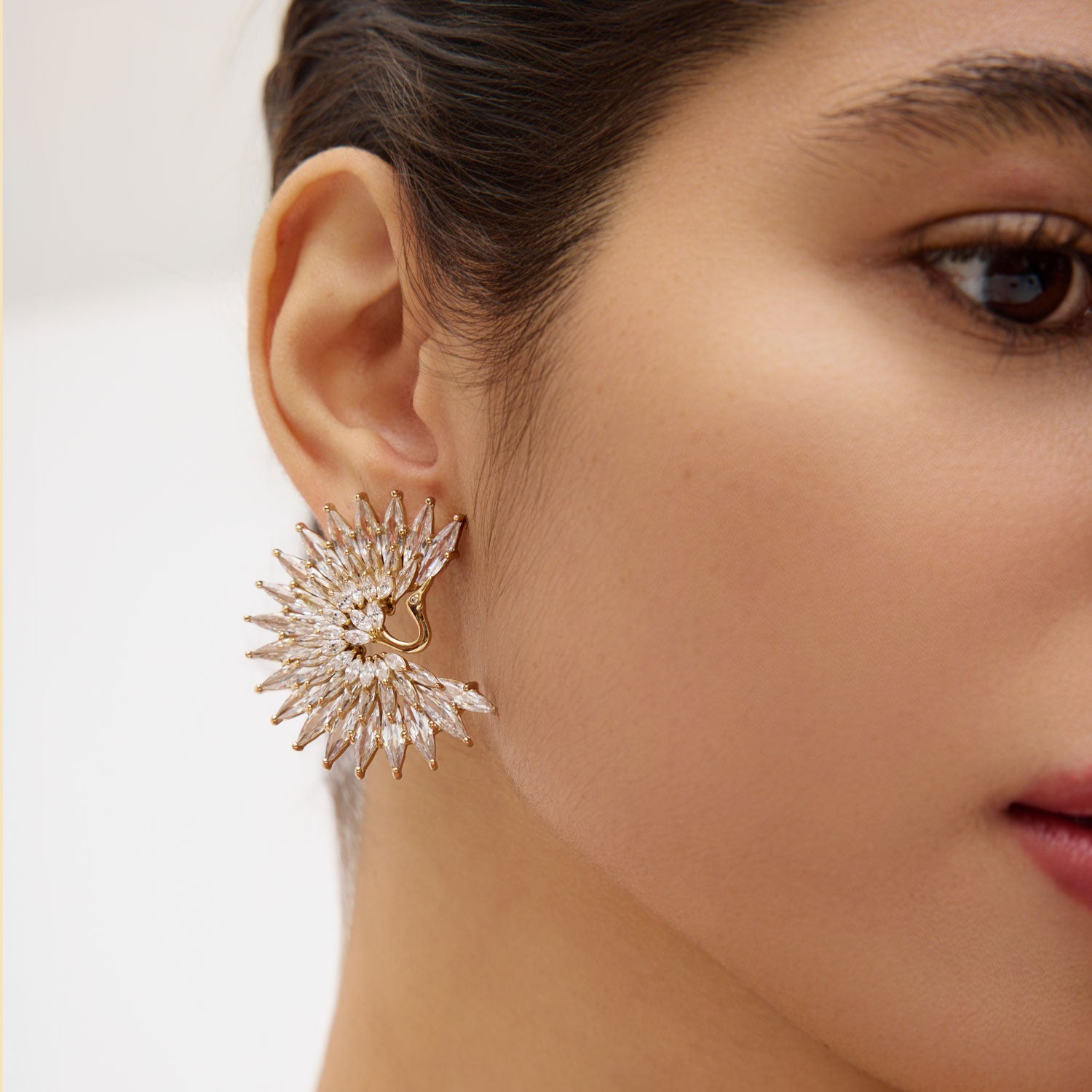 Close up of woman wearing crystal and gold stud earrings