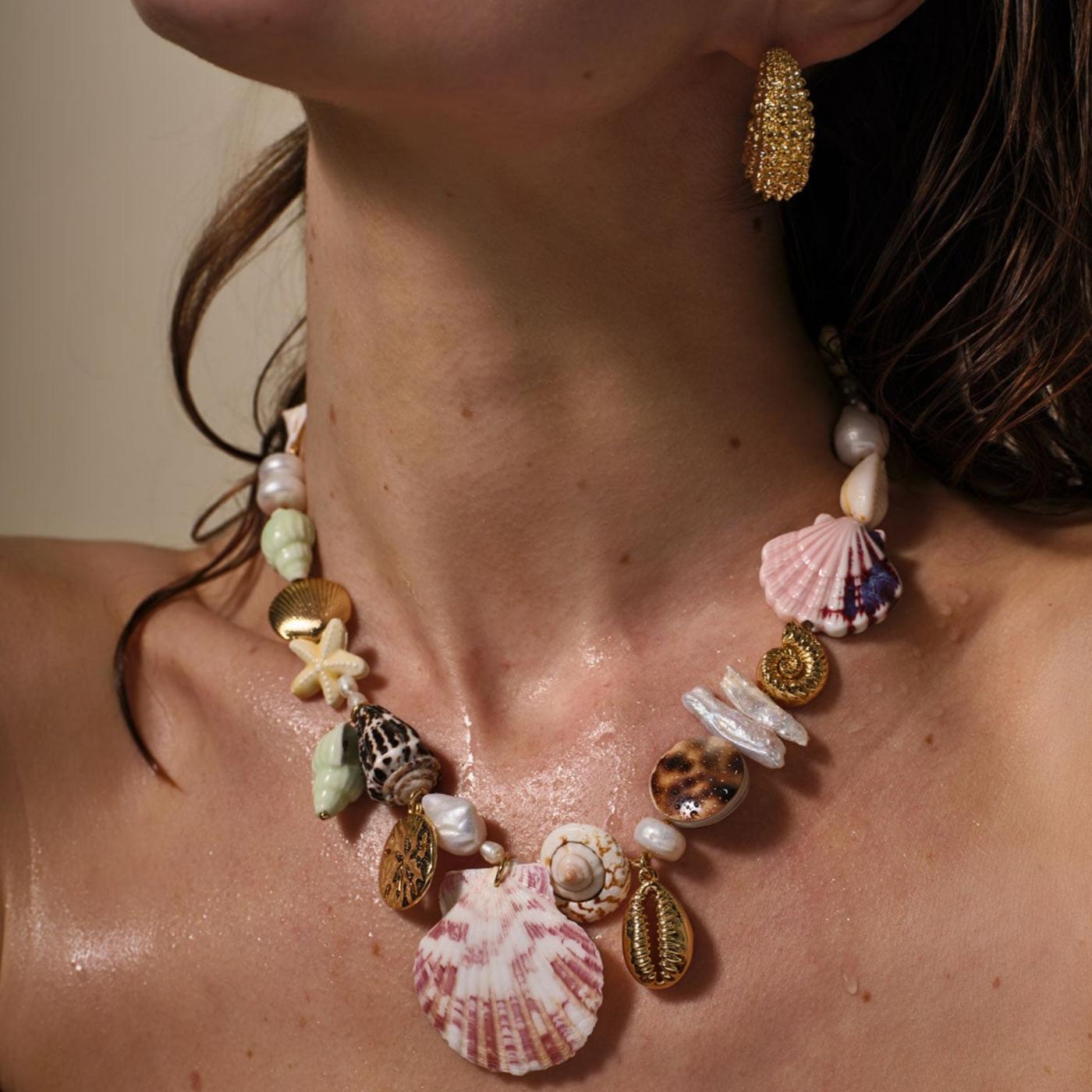 Necklace with seashell and starfish pendants on a person's neck