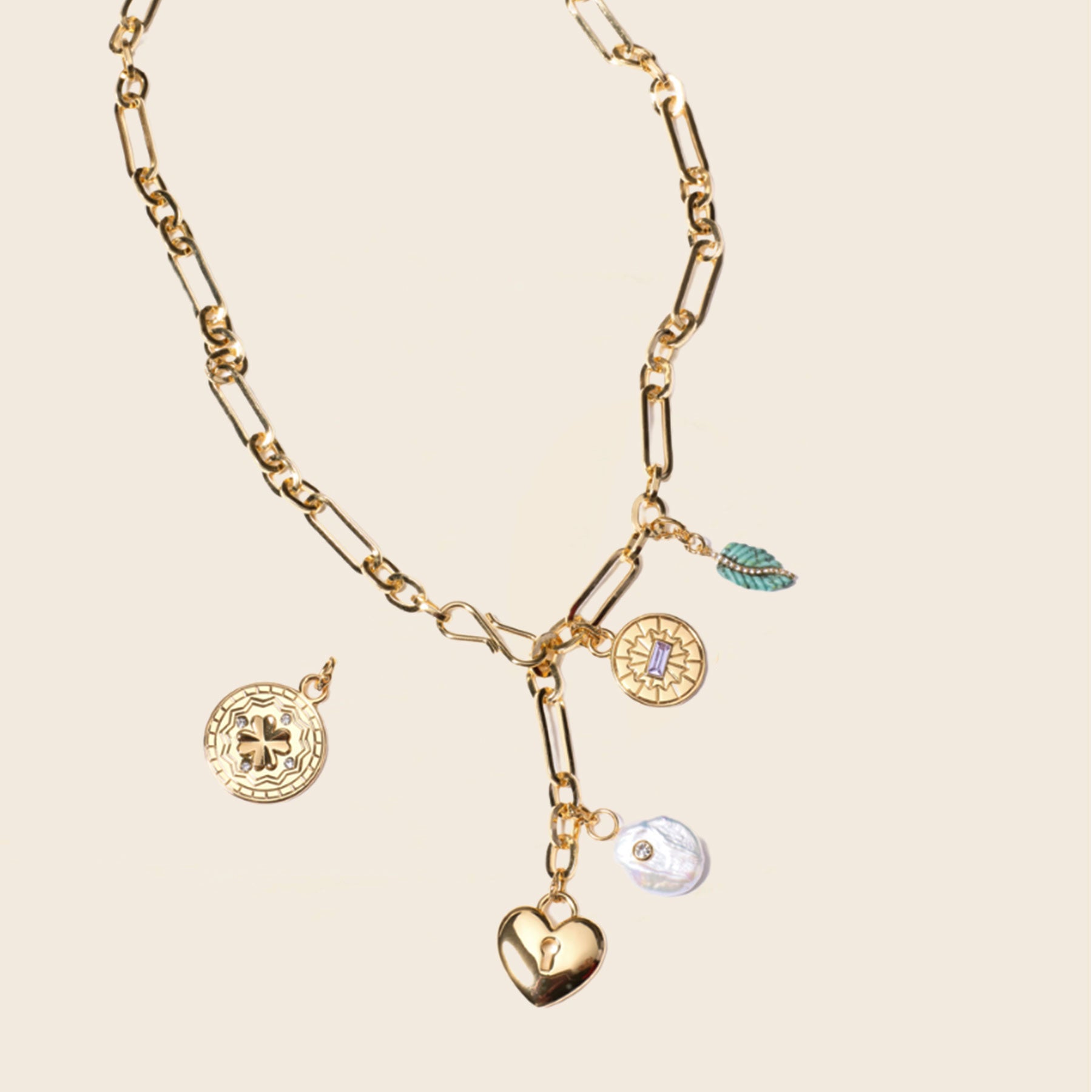 Gold Chain Charms Necklace on Tan Background