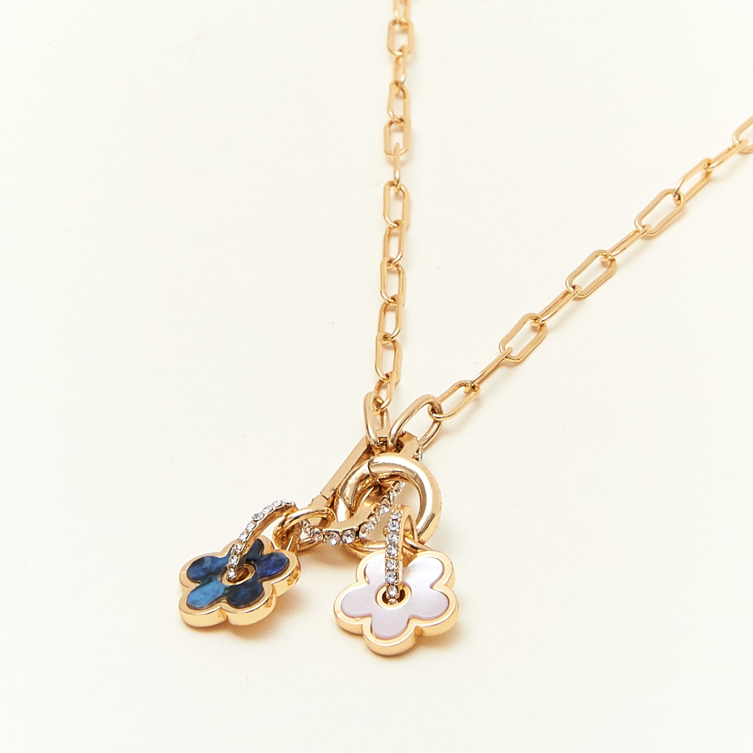 Gold necklace with floral pendants on a white background