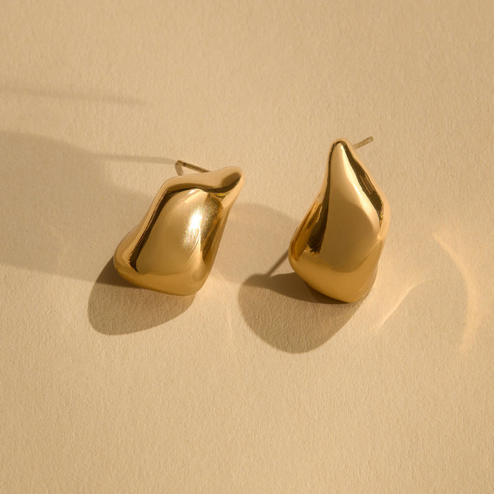 Gold Organic Shaped Stud Earrings on Staged on Cream Surface