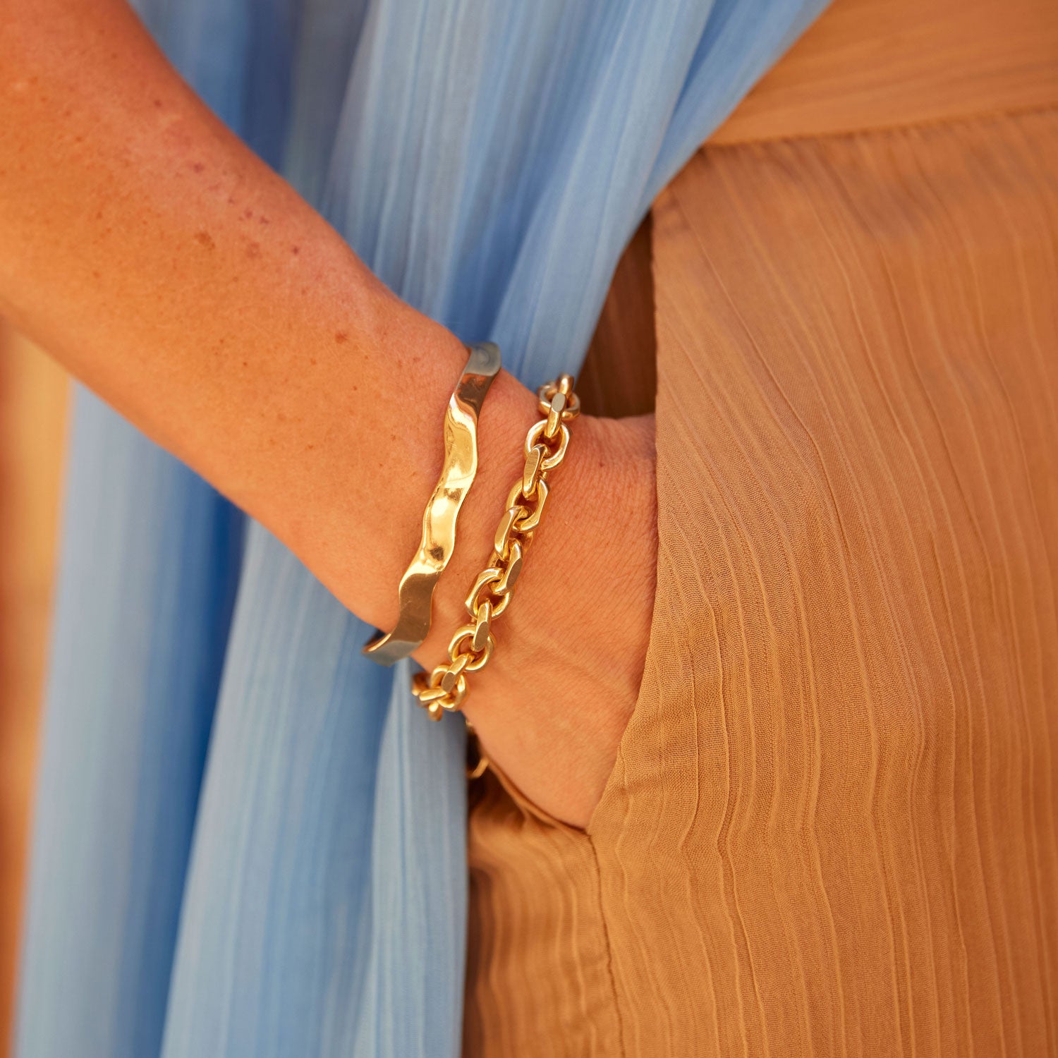 Wavy Gold Cuff Bracelet On Wrist with Gold Chain Bracelet