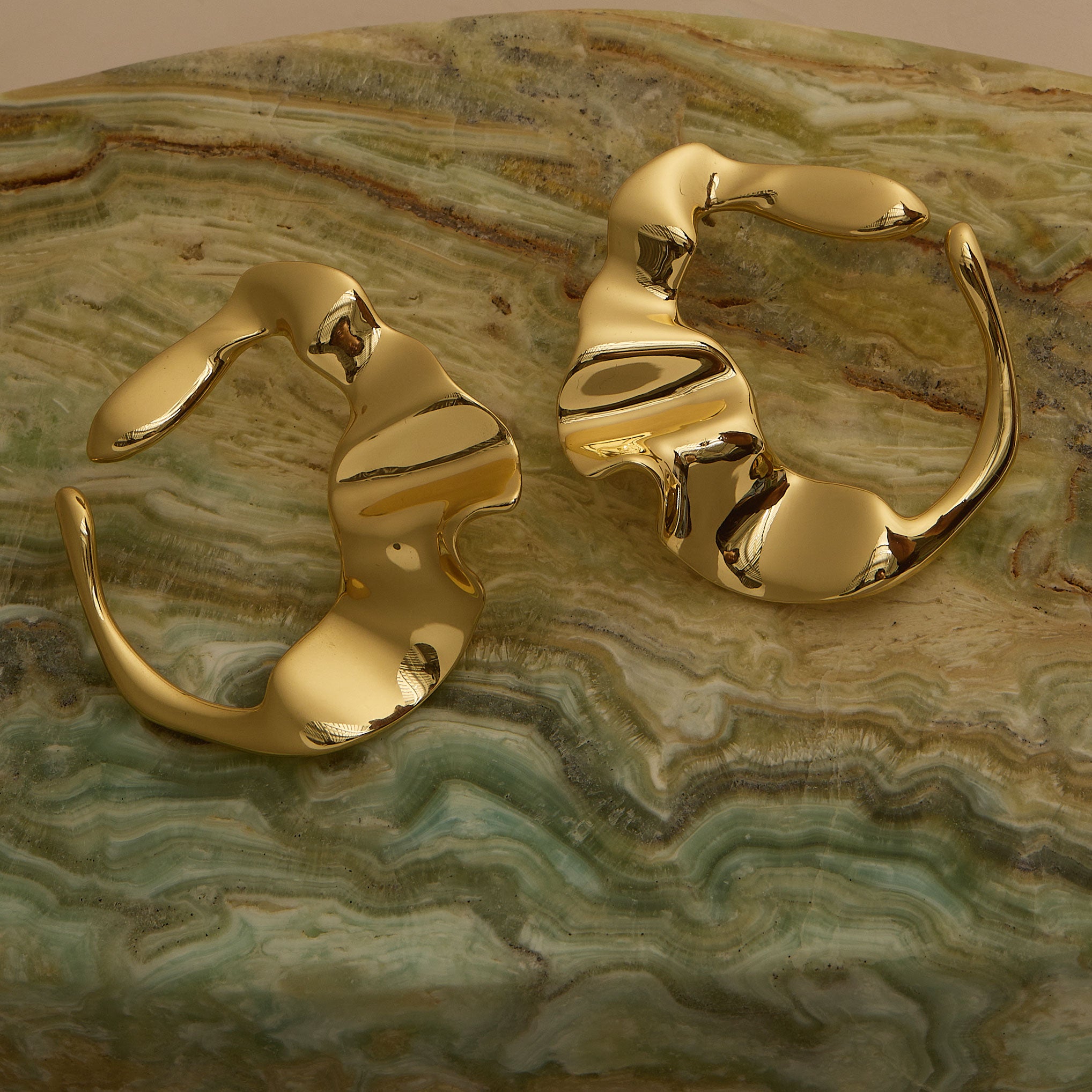 Organic Wavy Gold Studs on Marble Surface