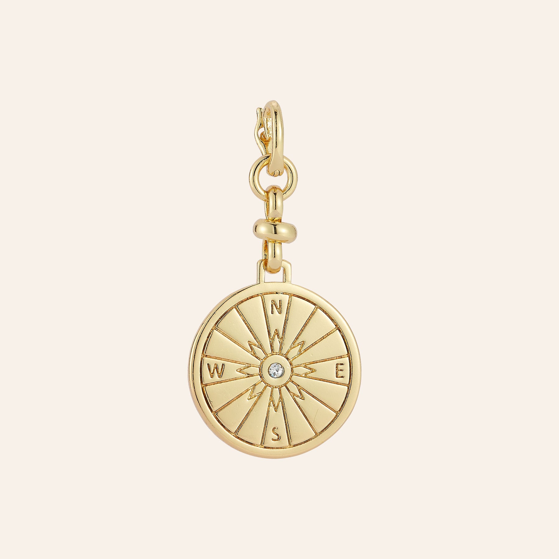 Gold and Crystal Compass Charm on Tan Background