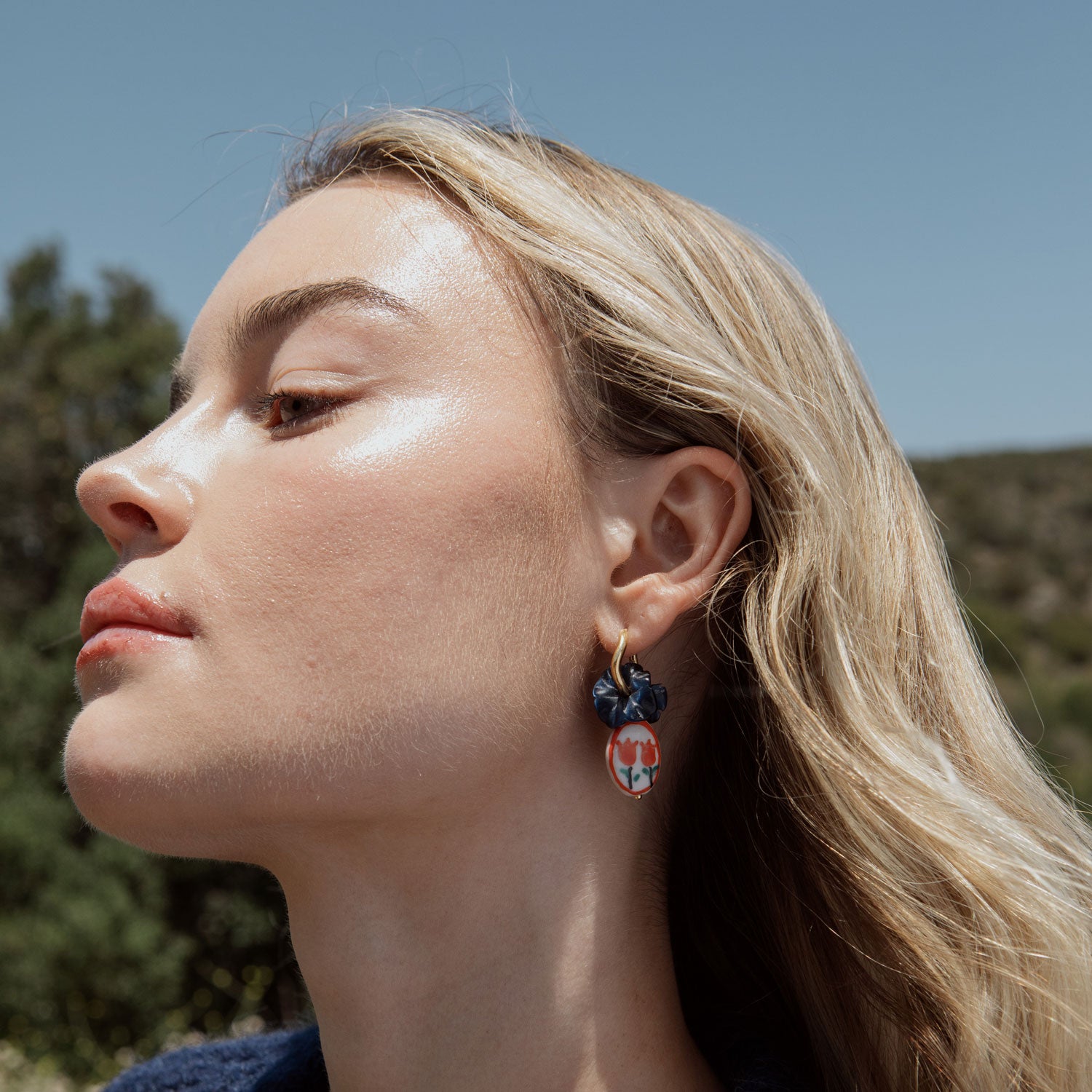 Earrings with Carved Lapis Flower Charms and Painted Red Tulip Charms Styled on Model