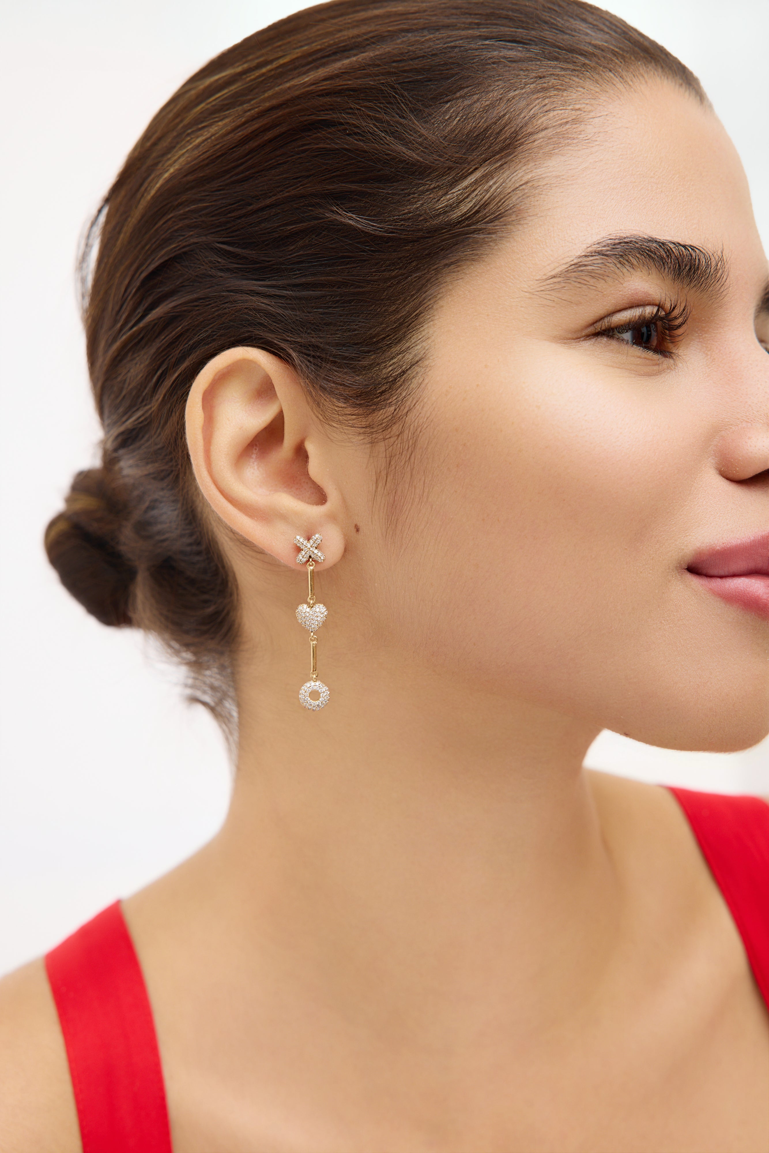Close-up of a woman wearing earrings with a plain background