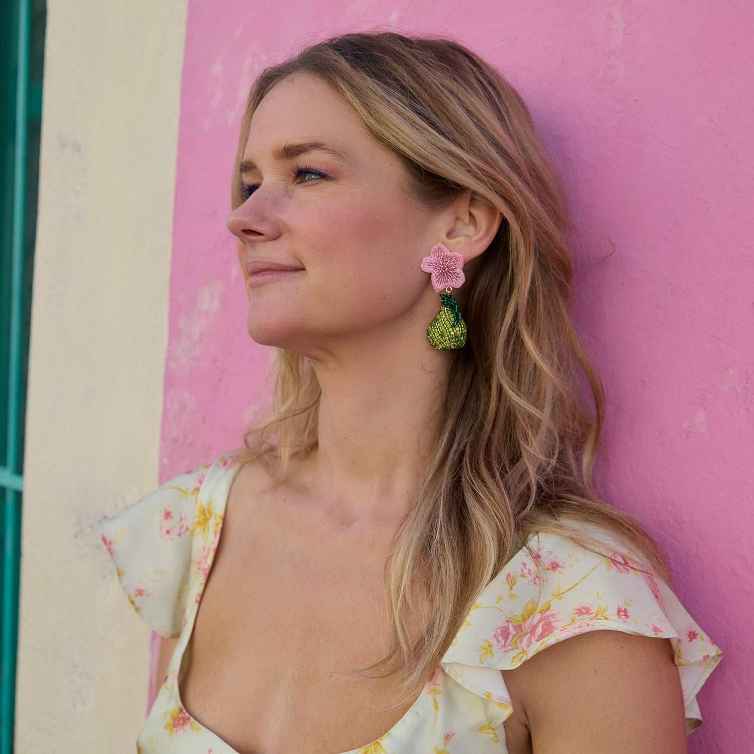 Woman with Pera Earrings against a pink wall