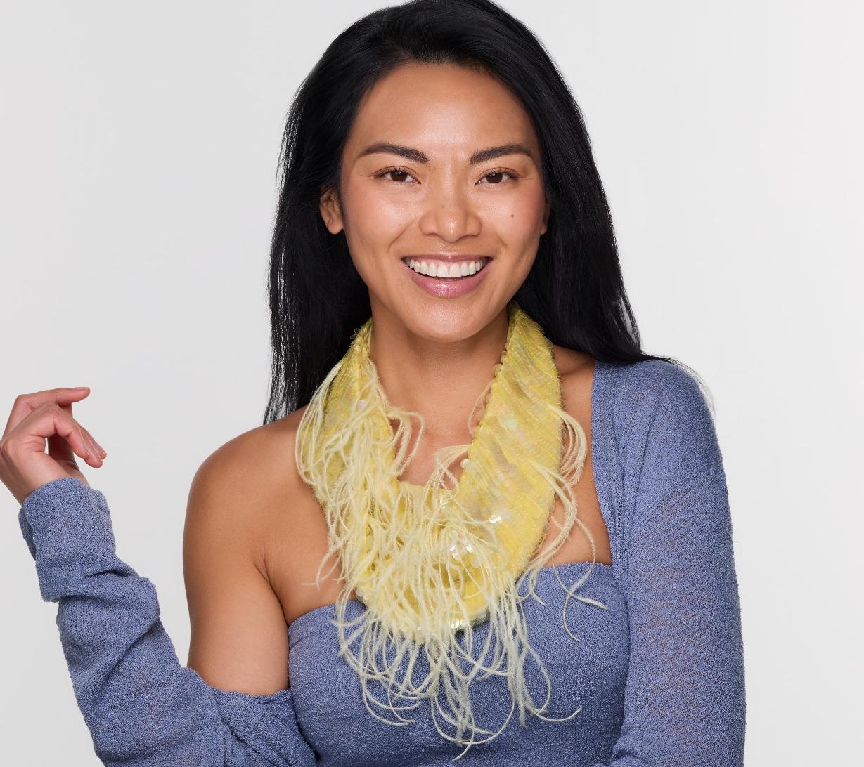 Woman wearing a yellow scarf against a plain background