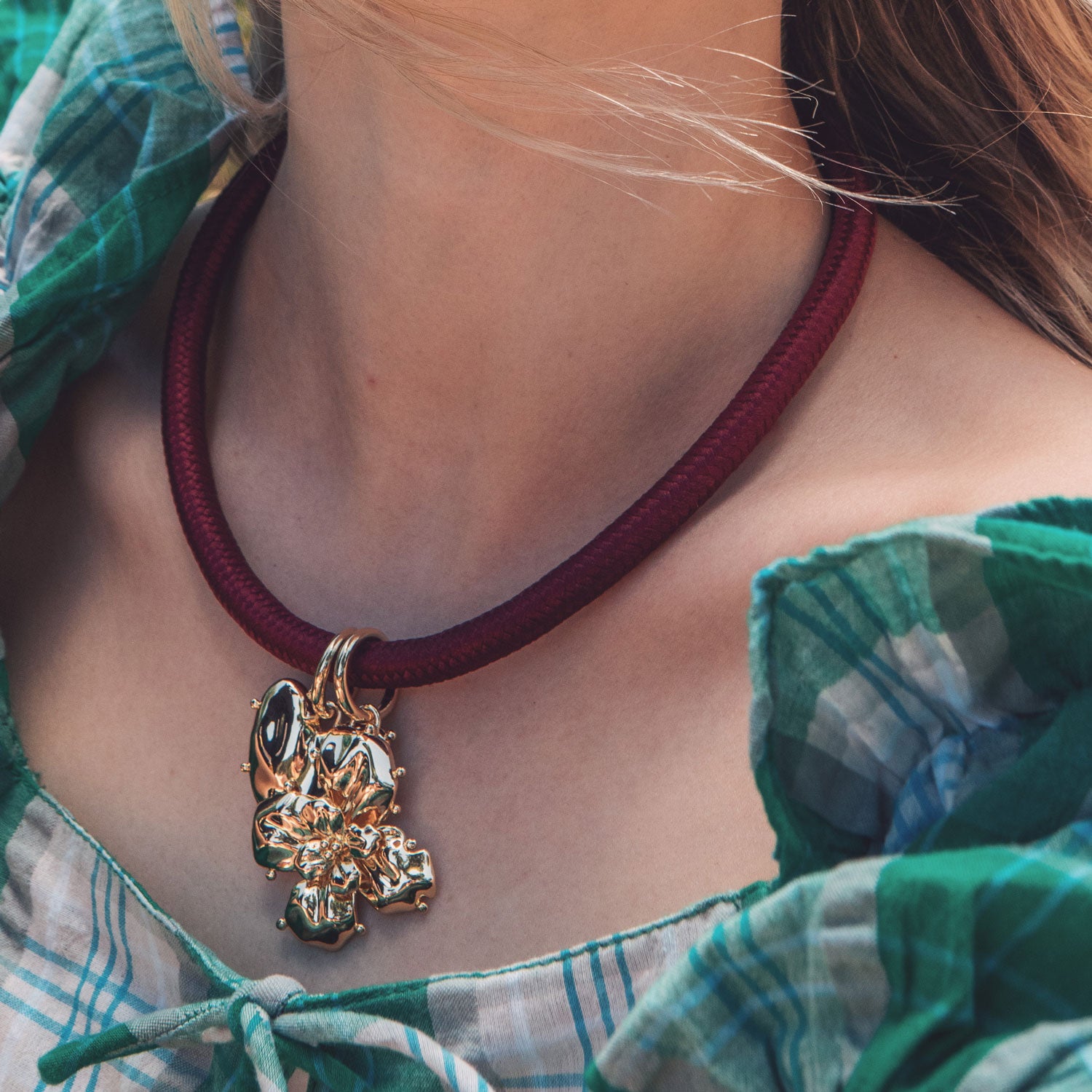 Red Cord Necklace with Gold Flower and Heart Charms Styled on Model