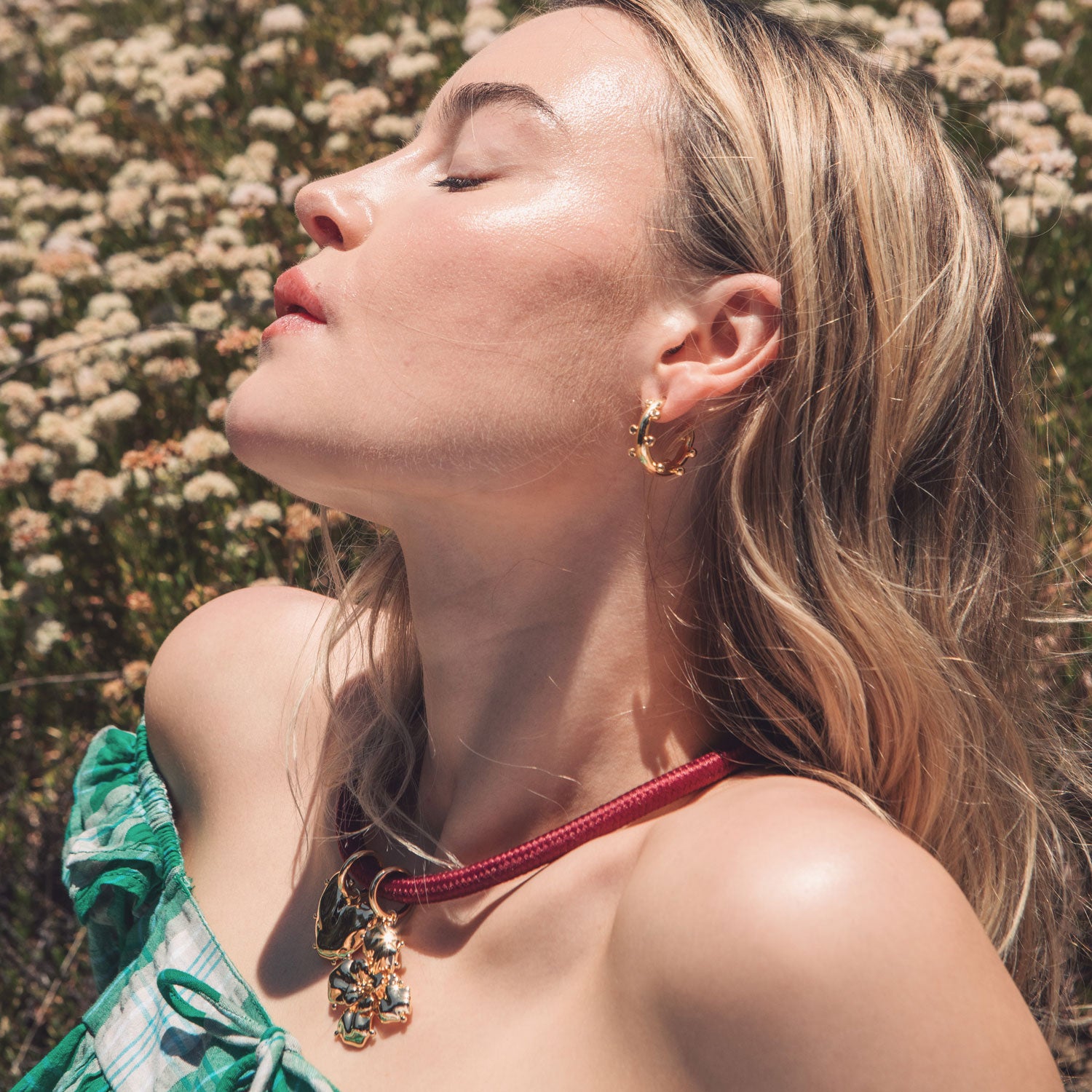 Red Cord Necklace with Gold Flower and Heart Charms Styled on Model