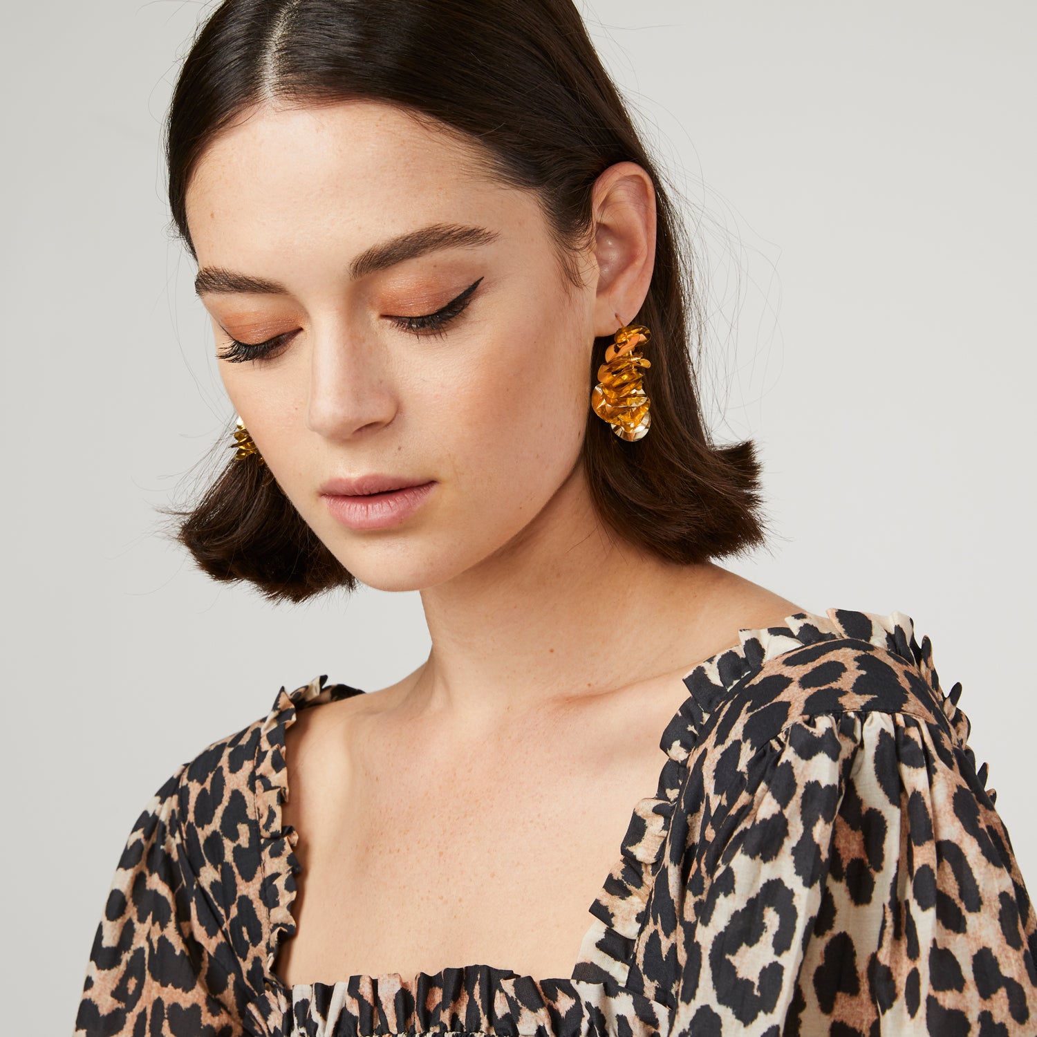 Metallic Gold Wavy Sequins on Thin Gold Hoop on Brunette Model with Cheetah Print Blouse