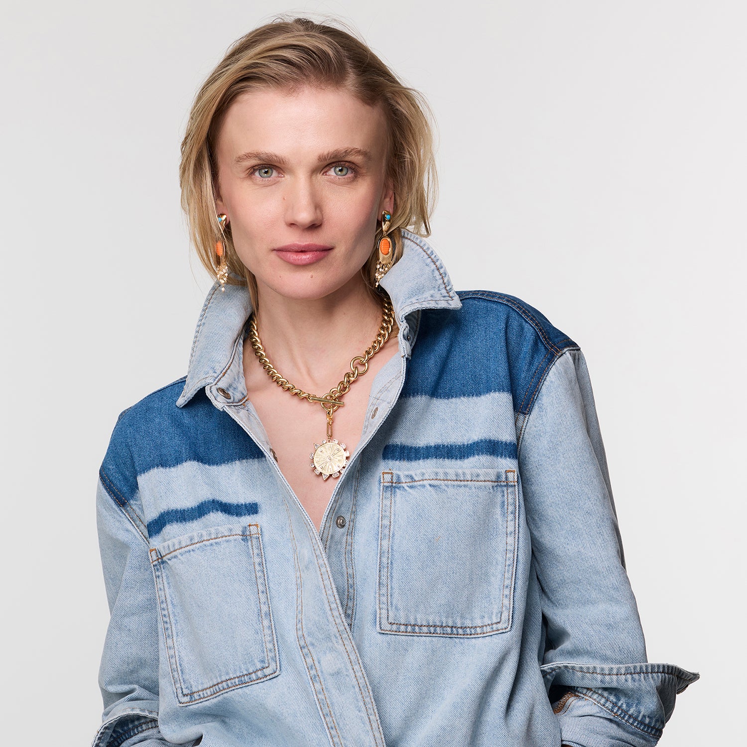 Woman wearing a blue denim shirt with a white background