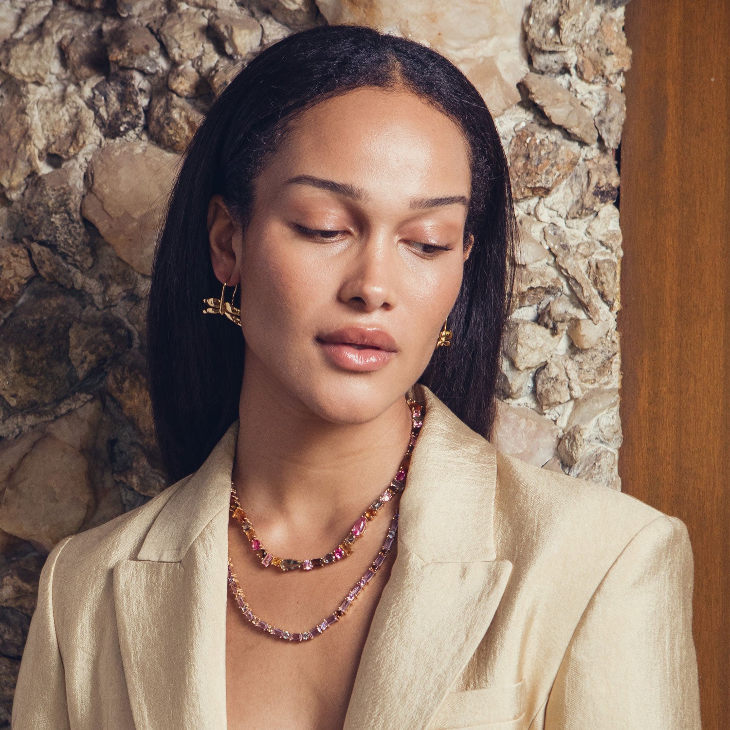 Colorful crystal tennis necklace with pink, green, and amber stones styled on model