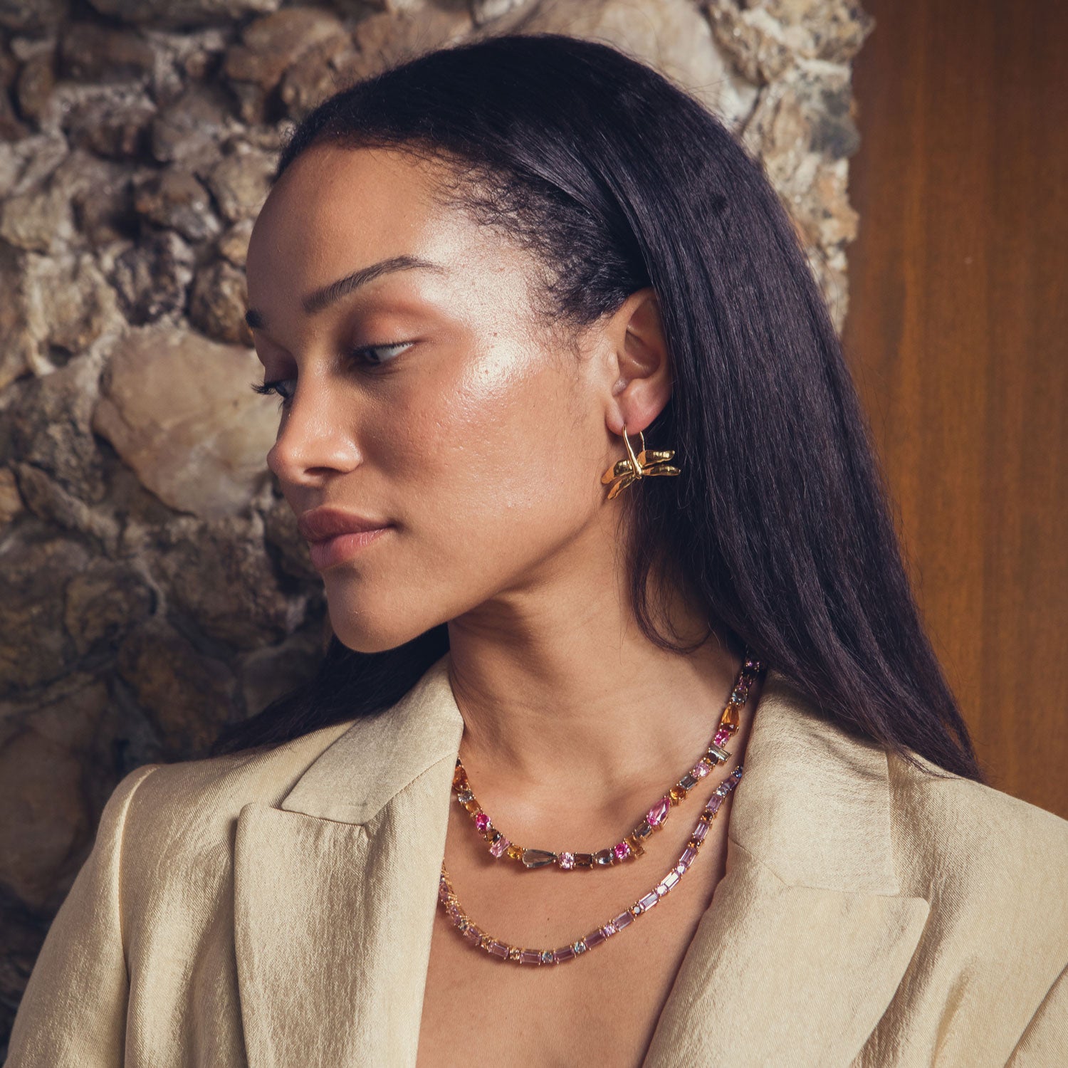 Colorful crystal tennis necklace with pink, green, and amber stones styled on model