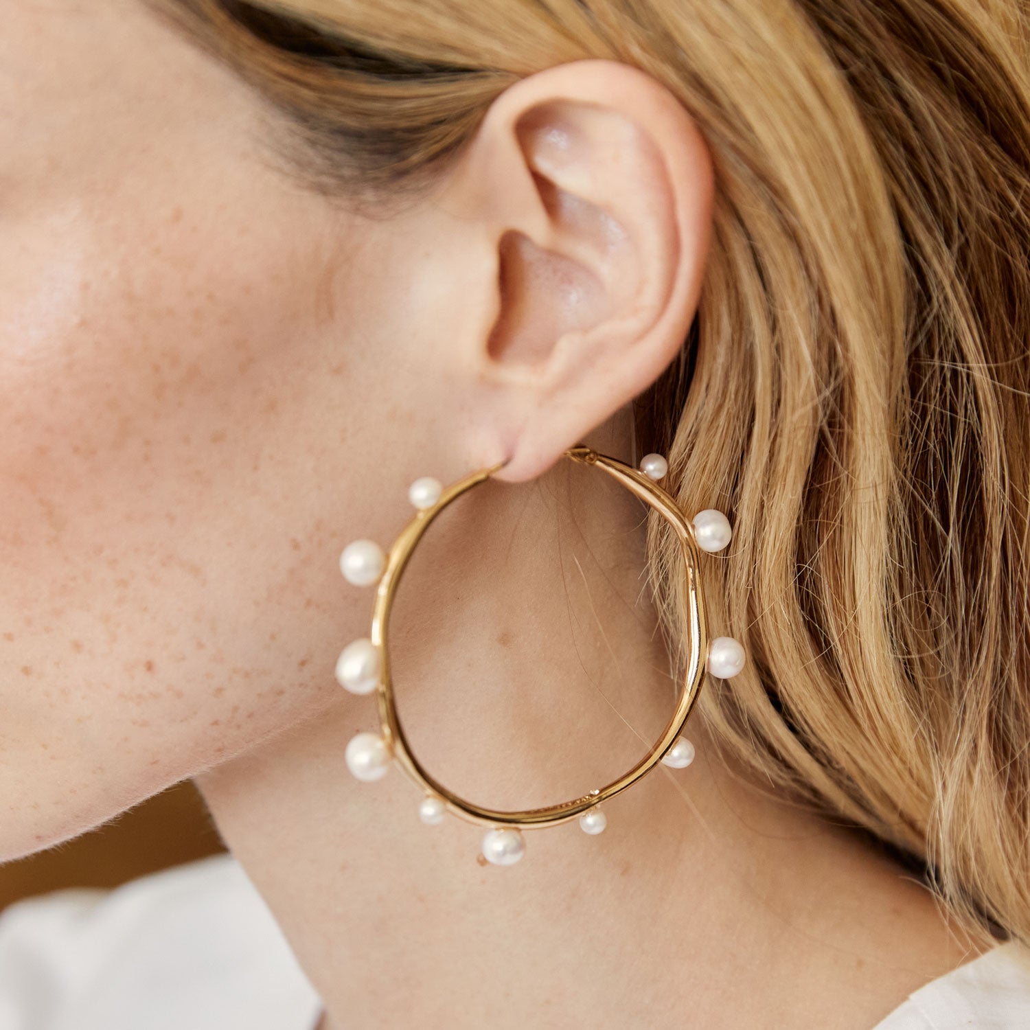 Organic Shaped Gold and Pearl Hoop Earrings Styled on Blonde Model's Ear