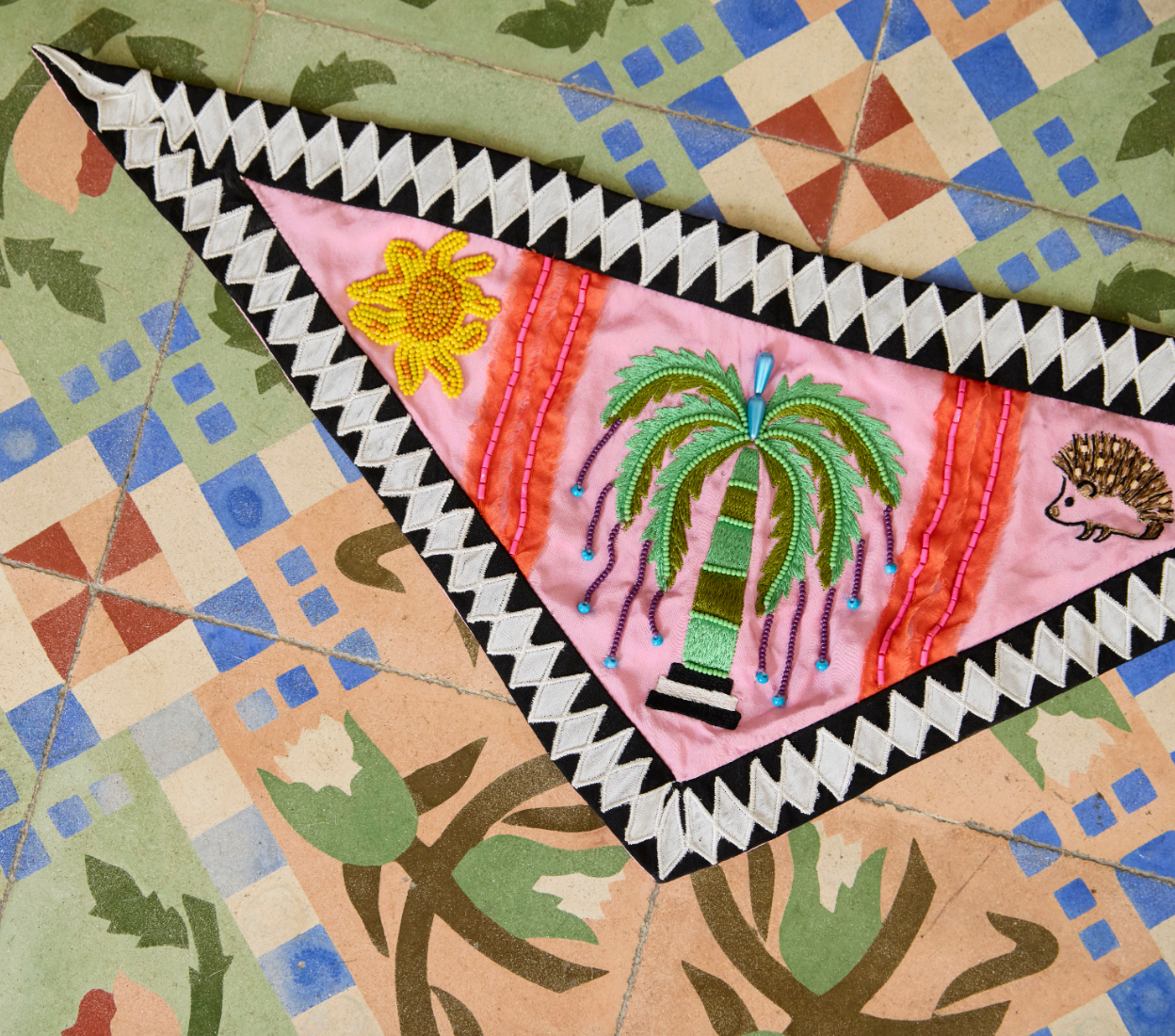 Decorative quilt with embroidered elements on a patterned fabric background
