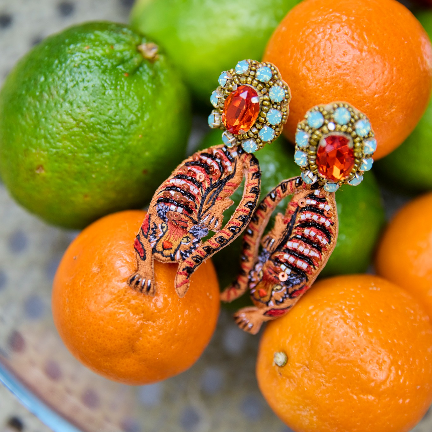 Tiger-themed earrings with gemstones on oranges and limes