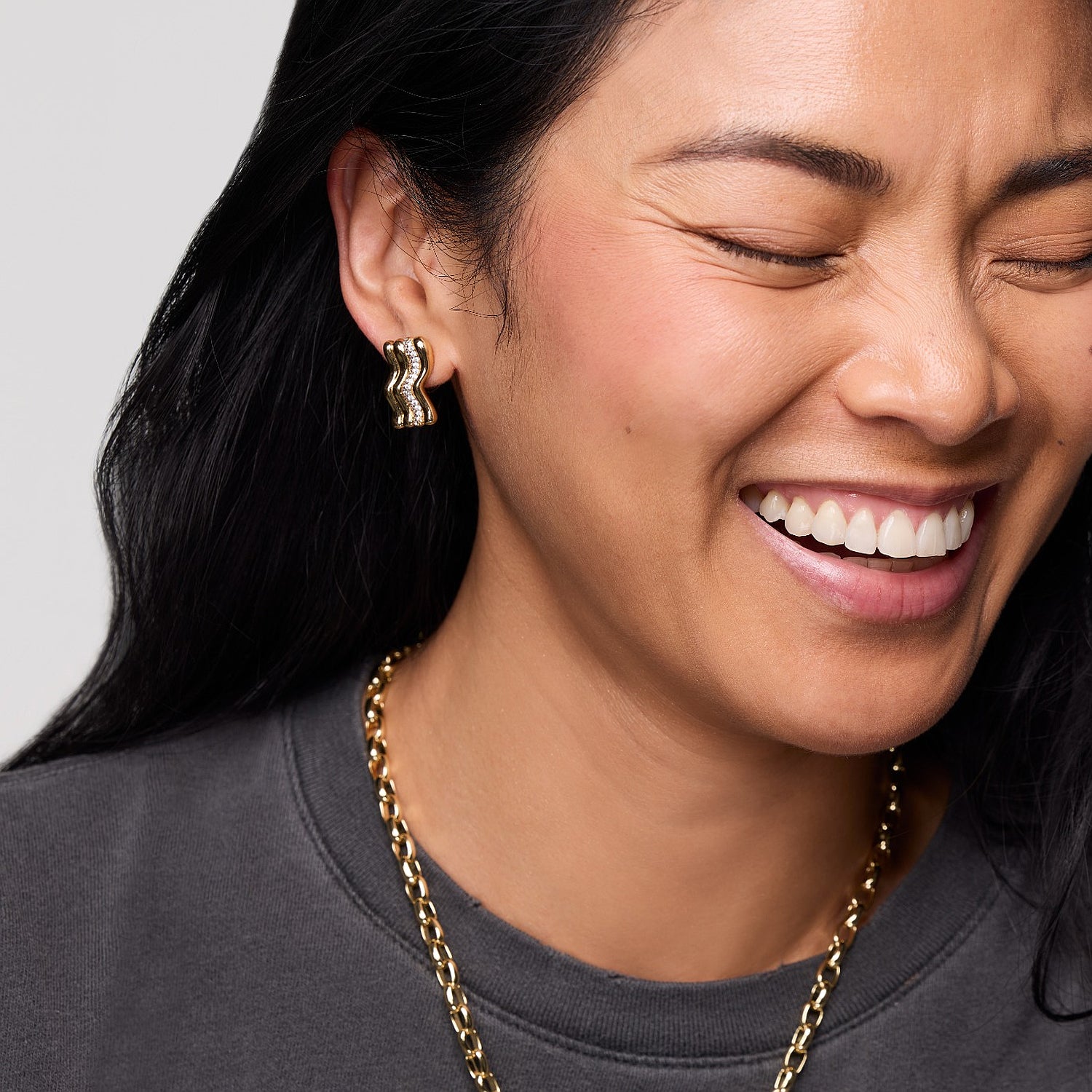Model wearing gold and crystal stud earrings