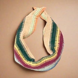 Red, Blue, Green, Yellow, Orange, and Tan Beaded Scarf Necklace on Tan Background