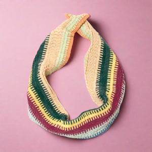 Red, Blue, Green, Yellow, Orange, and Tan Beaded Scarf Necklace on Pink Background