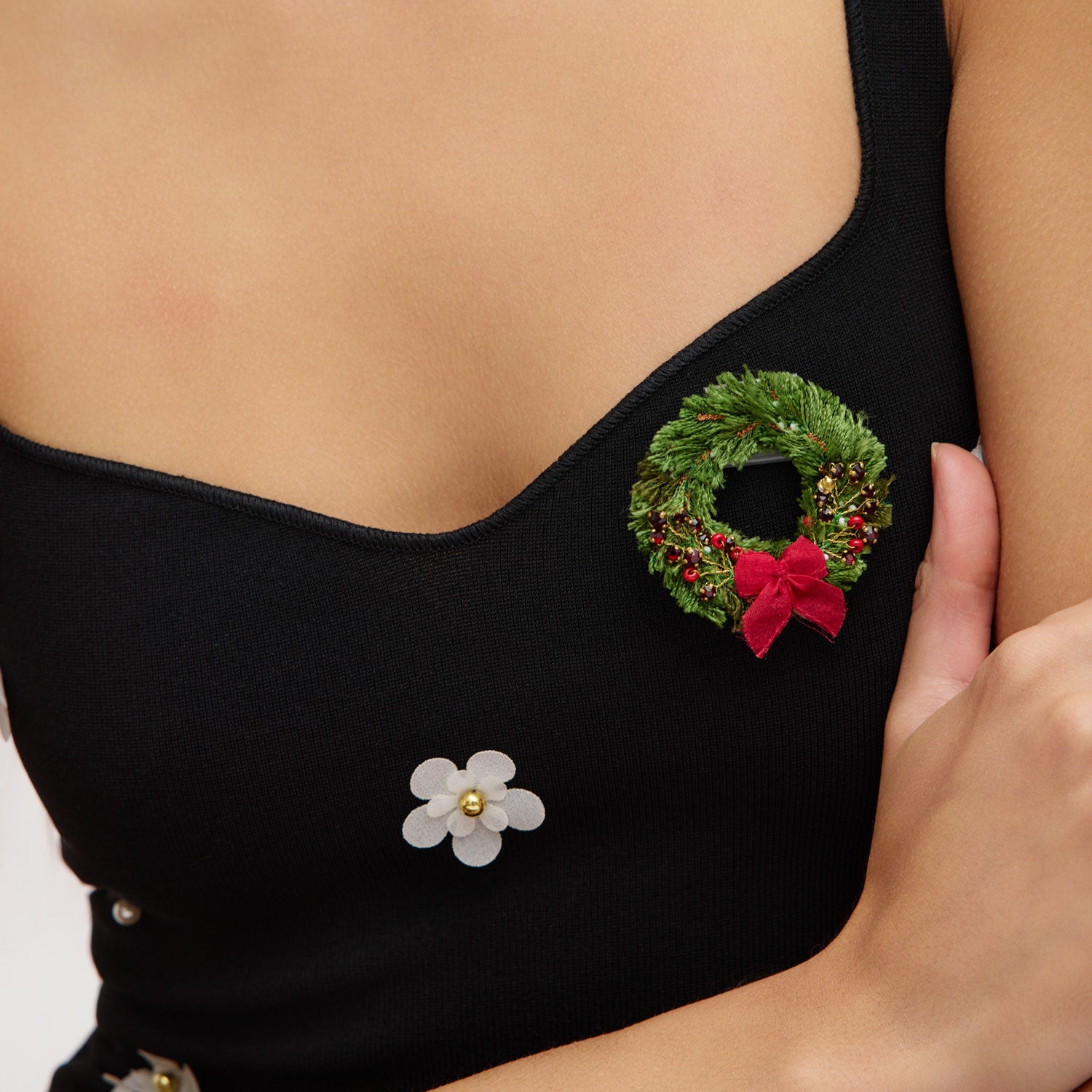 Black top with floral and wreath embellishments