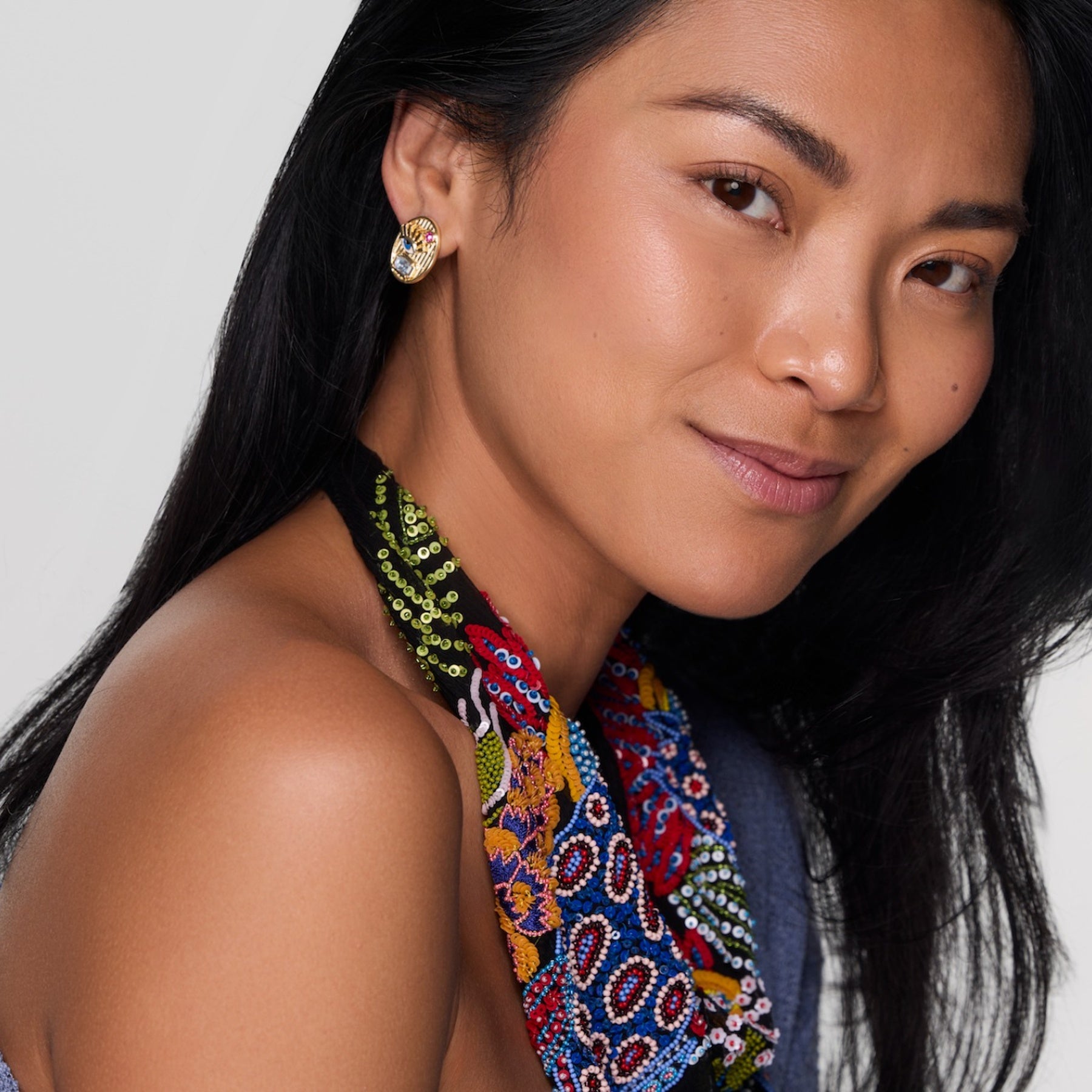 Model wearing gold studs with beaded scarf necklace.