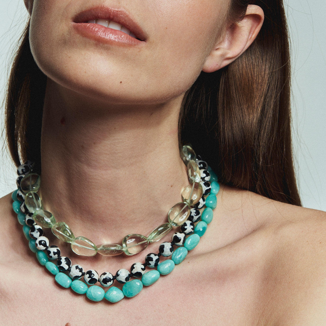 Black and White Beaded Strand Necklace Styled on Model with Blue and Green Strand Necklaces
