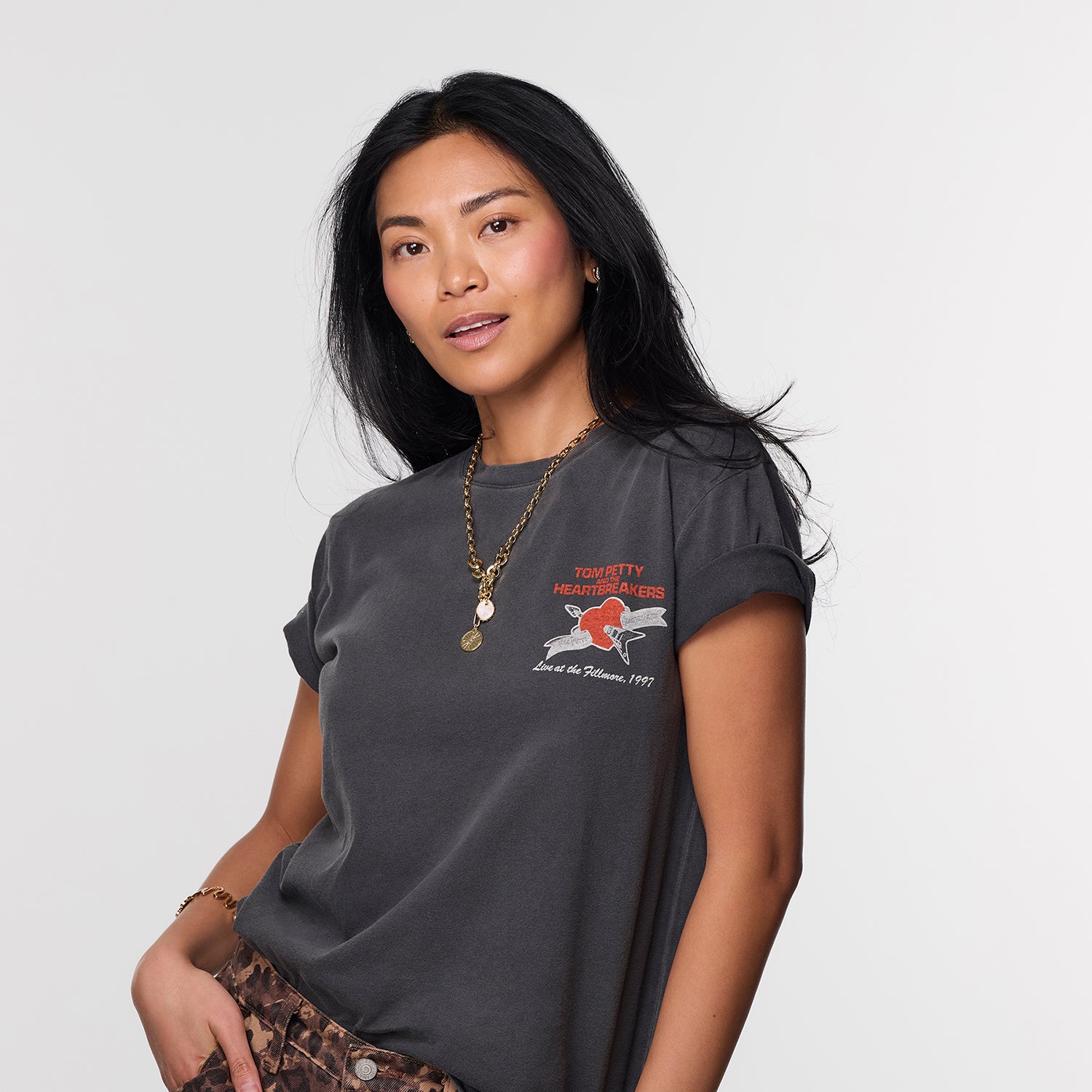 Woman wearing a dark gray t-shirt with a graphic design on a plain background