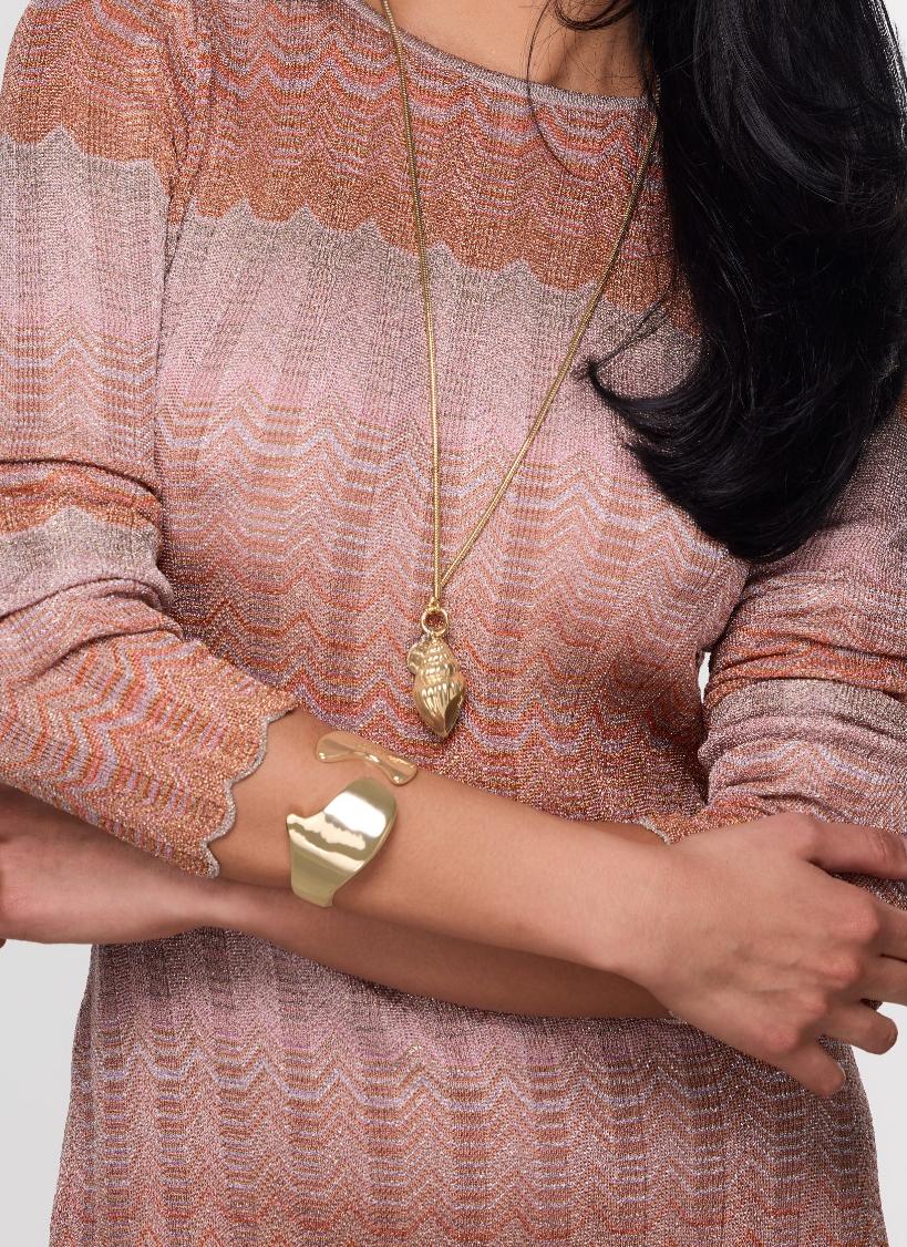 Gold bracelet cuff on model's wrist