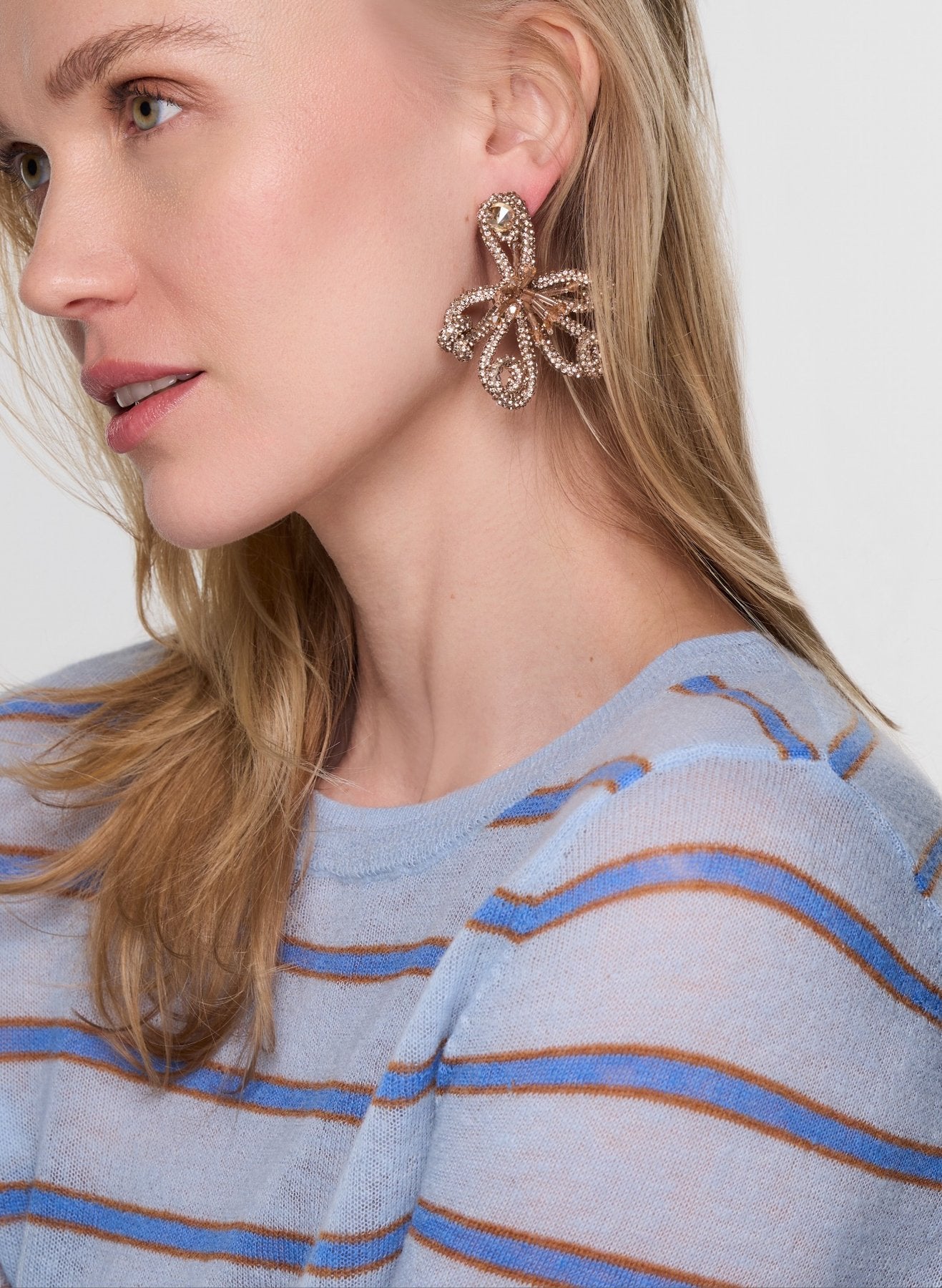Close-up of a woman wearing a decorative earring with a white background