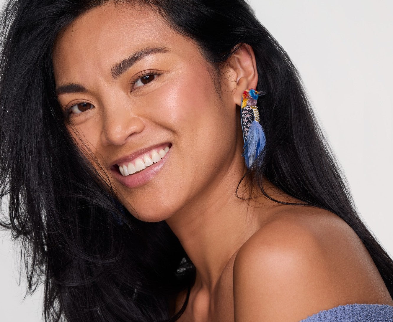 Blue bird earrings with feathers and leather on model