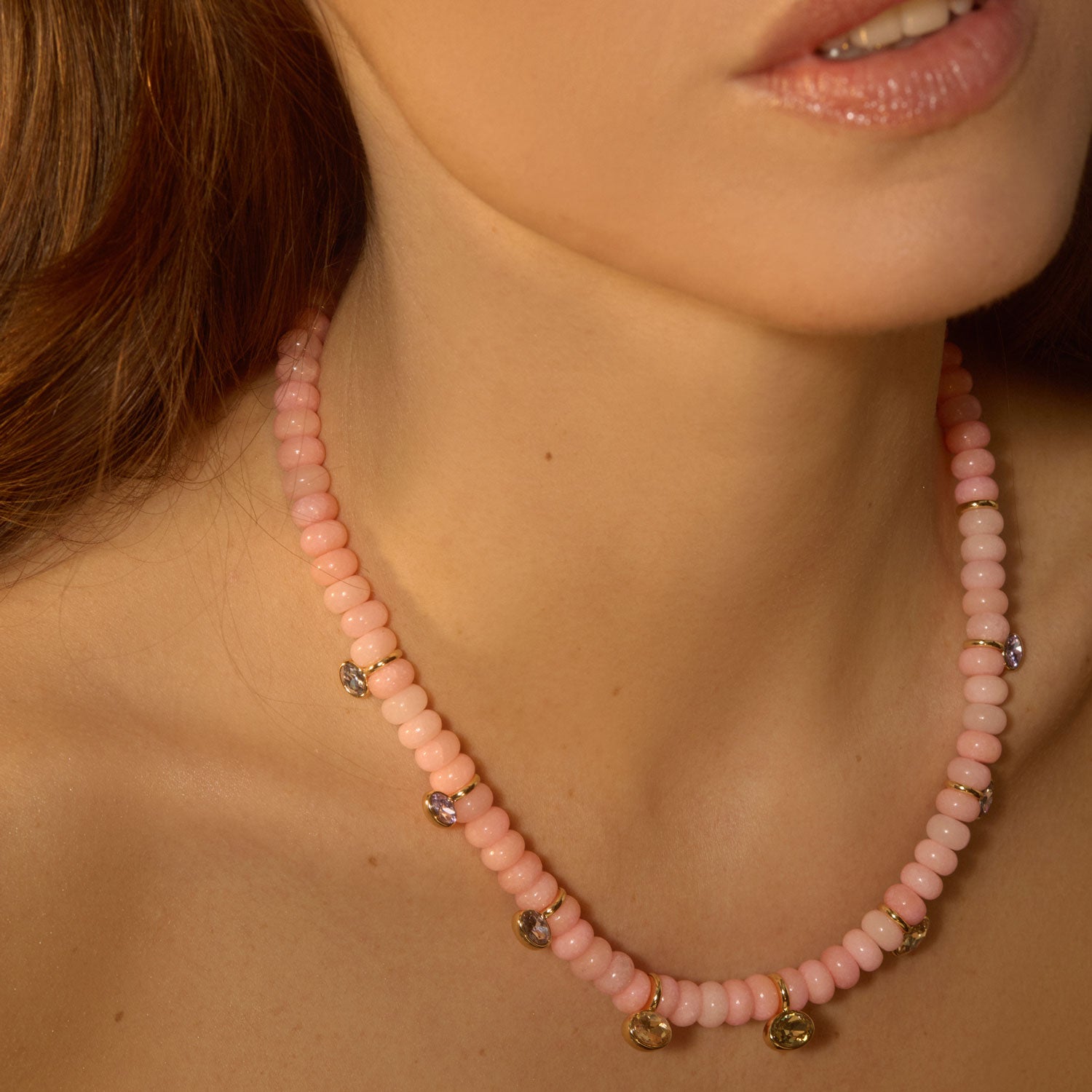strand necklace with pink beads and crystals worn and tightly framed around the neck