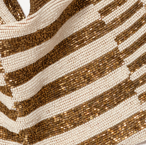 close up of cream seed beads and golden bronze tube beads in striped sections on a scarf necklace