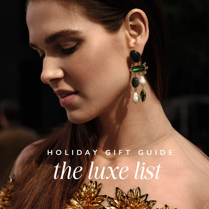 "Holiday Gift Guide the luxe list" text overlay on an image of a woman wearing dangle earrings with pearls semi precious stones and crystals