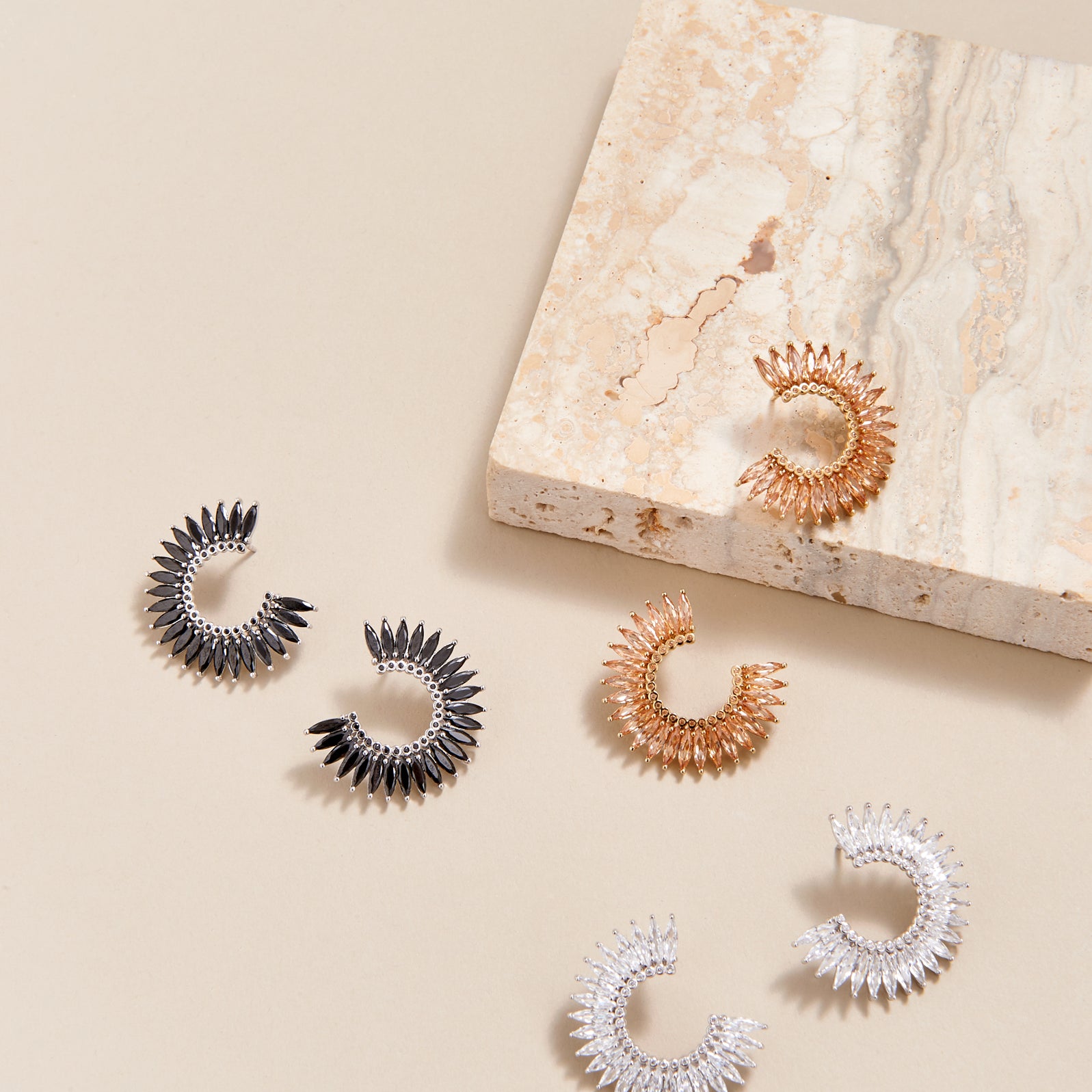 three pairs of crystal hoop earrings shown in black, silver, and champagne