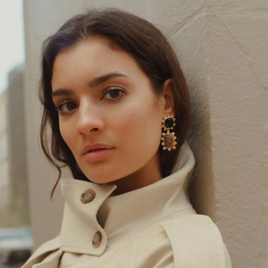 woman modeling crystal drop earrings wearing a winter coat with hair tucked into the coat collar