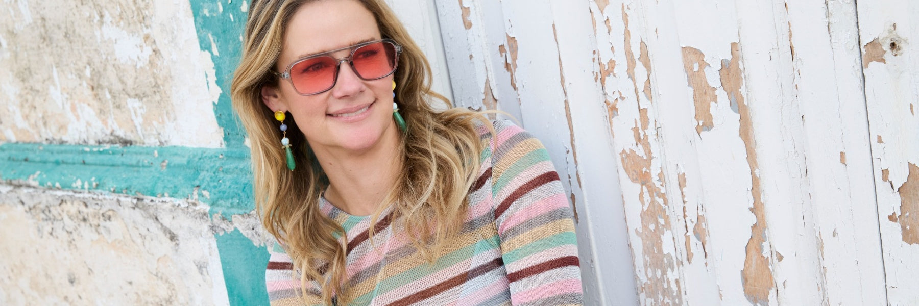 Model wearing colorful and bold earrings with sunglasses