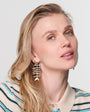 Woman wearing fishbone earrings with a neutral background