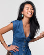 Woman wearing a blue denim dress against a plain background