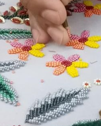 Hand embroidery process with colorful beads on fabric