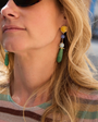 Close-up of a woman wearing colorful earrings with a blurred background