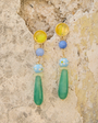 Colorful drop earrings against stone wall background